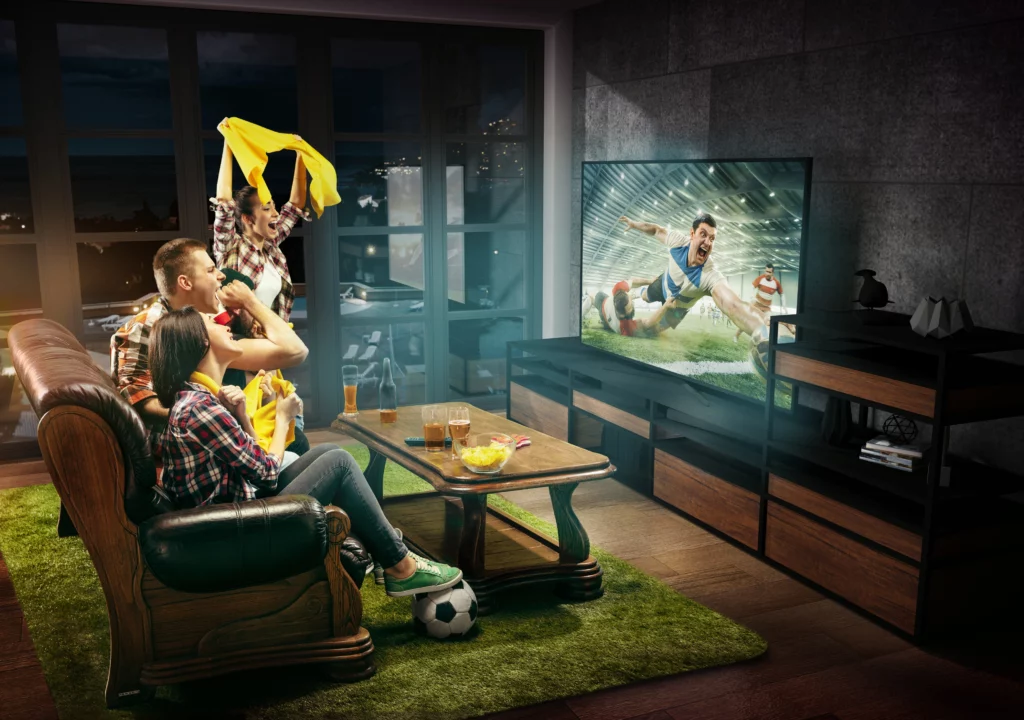 Trio de amigos assistindo futebol pela televisão